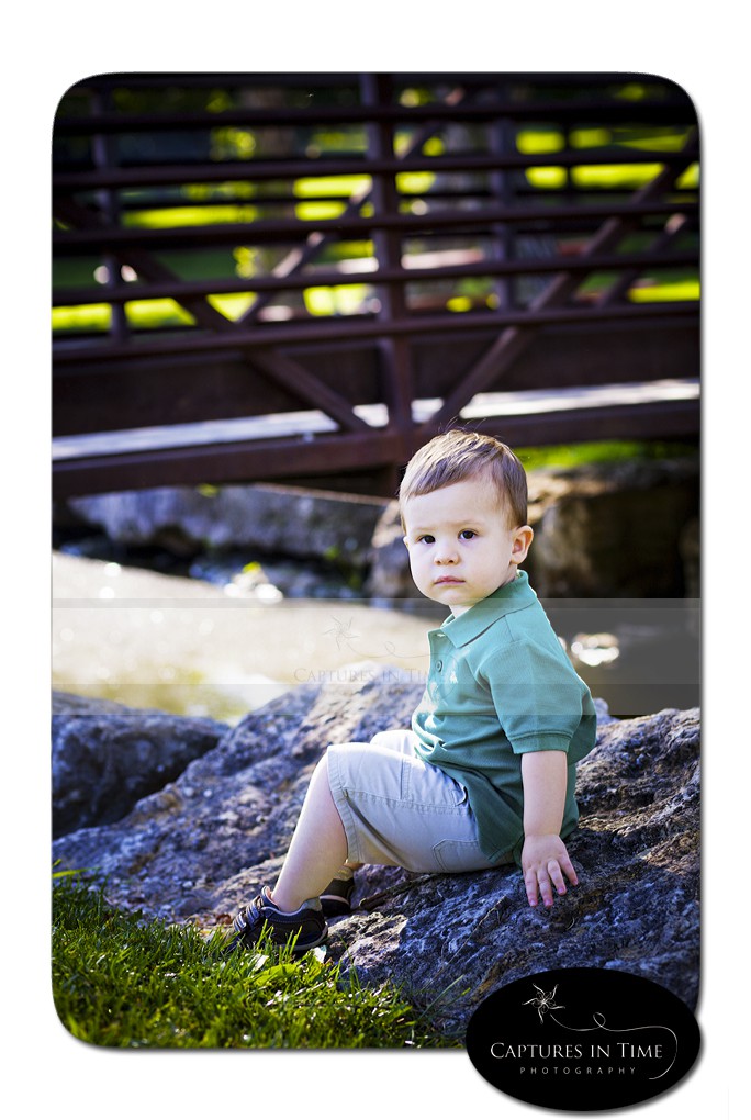 Kansas City Child Photographer boy sitting on a rock by a bridge