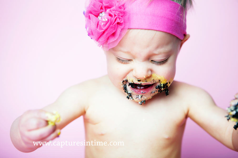 baby on hot pink eating chocolate cake close up 