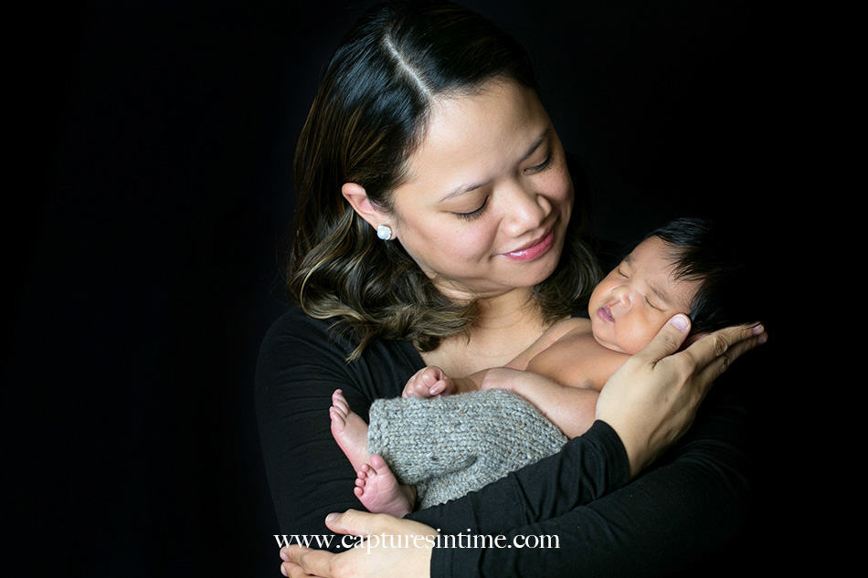 kansas city newborn photographer Mia newborn baby dark hair with her mom on black backdrop