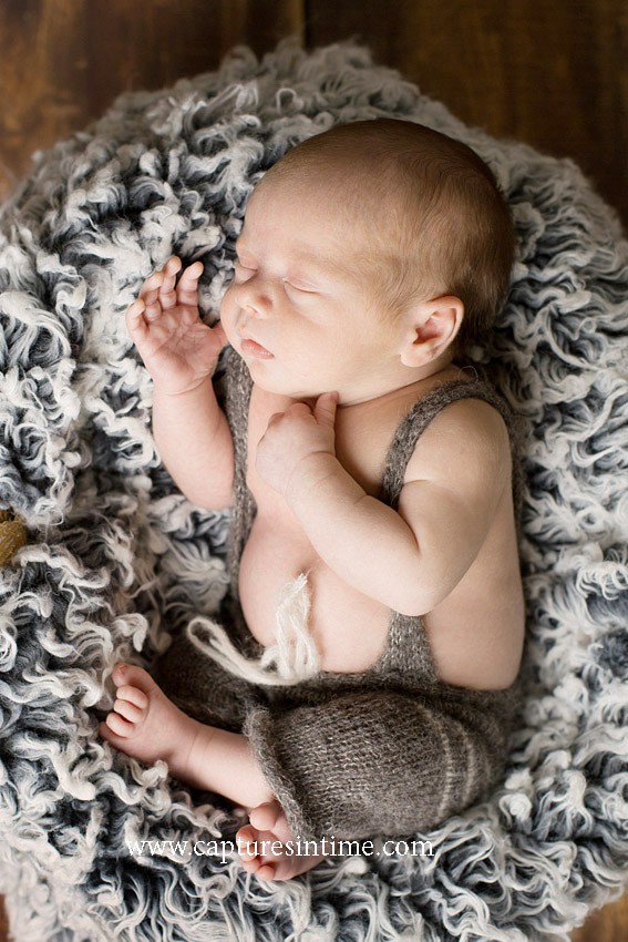 best kansas city newborn photos newborn boy in gray romper full length shot on gray blanket