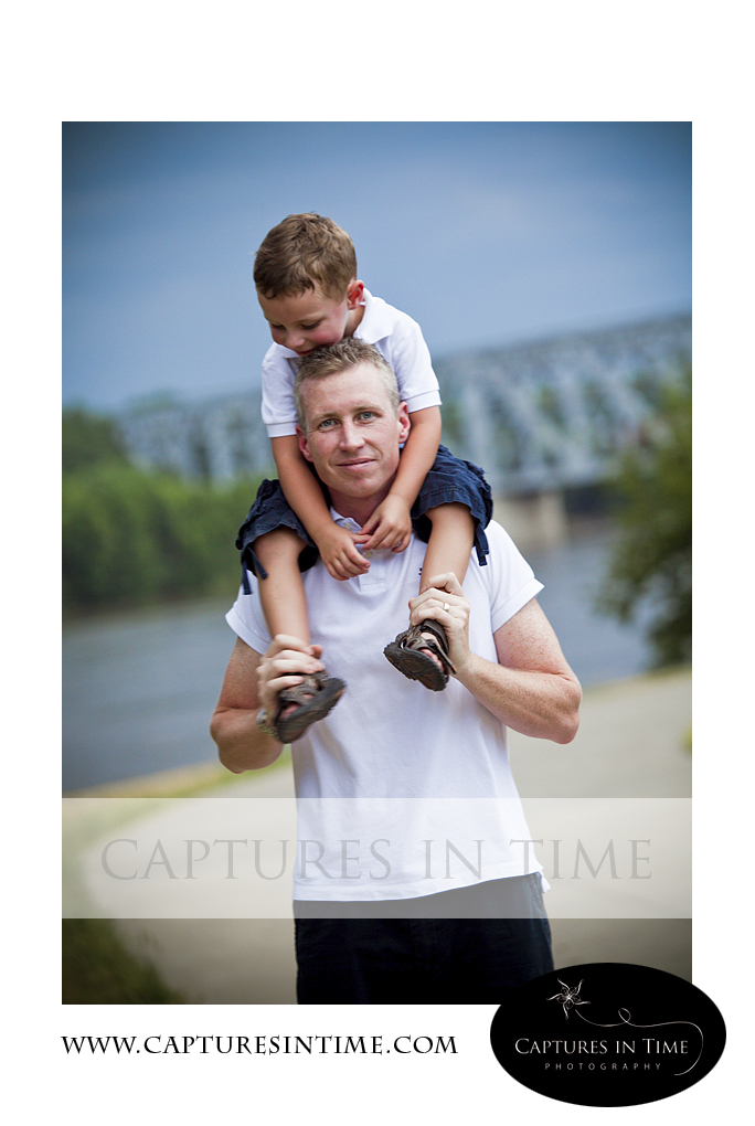toddler boy on dad's shoulders with bridge in background River Market