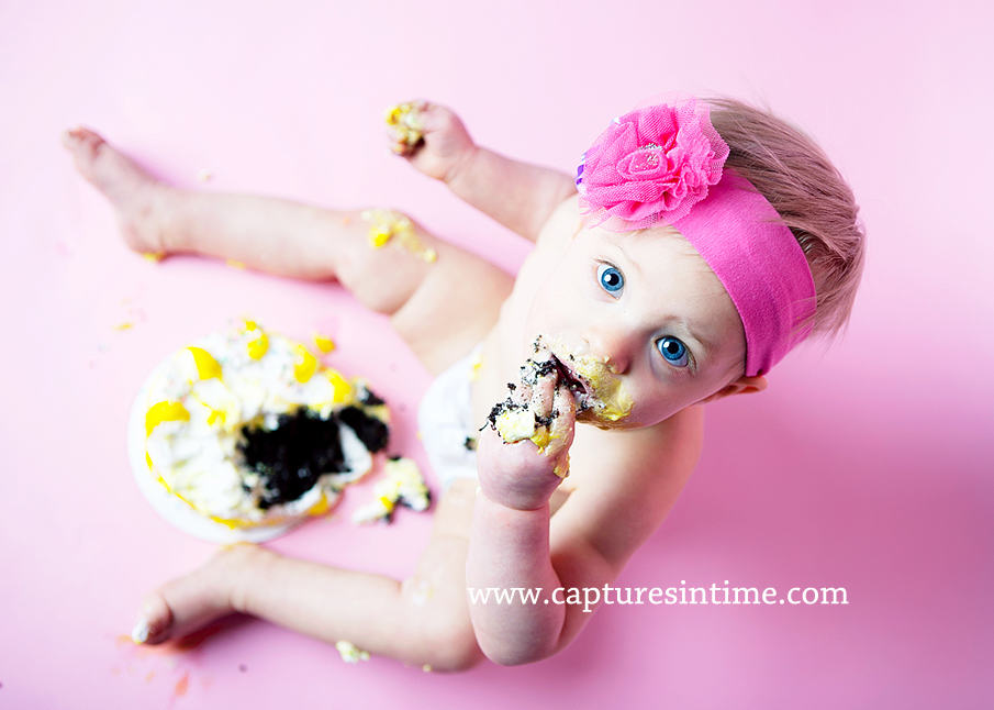 baby on hot pink eating chocolate cake
