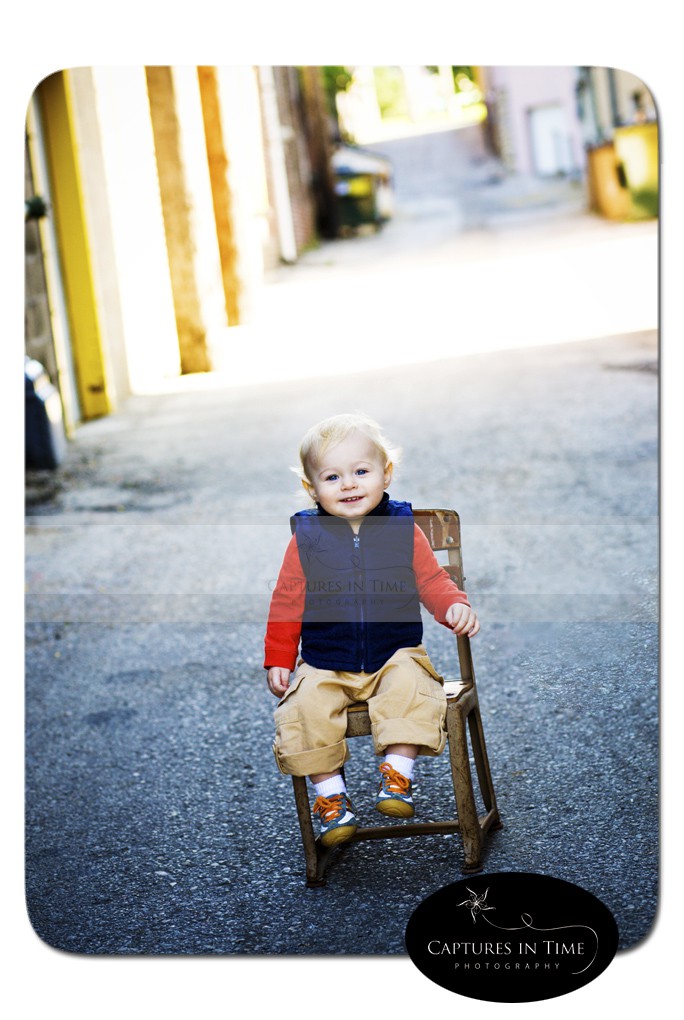 boy in vest sitting in an alley Kansas City