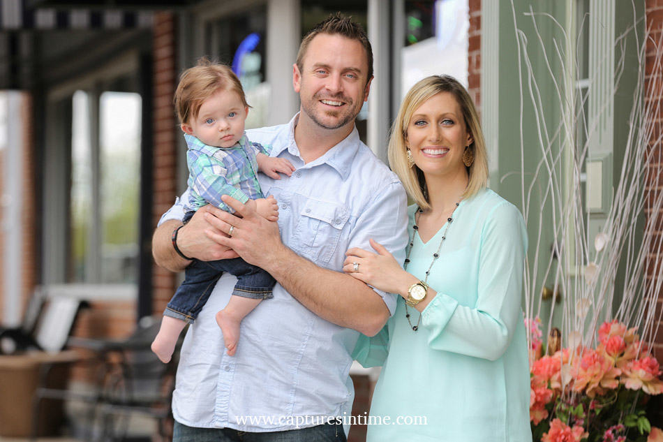 baby photography kansas city mom dad and red head baby boy on Main street in Blue Springs