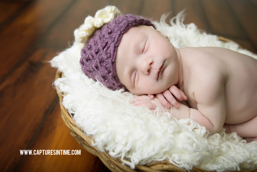 newborn girl with lavender hat