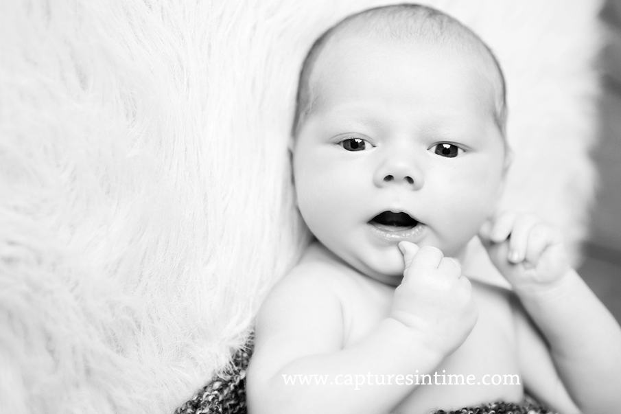 black and white baby with thumb on lip
