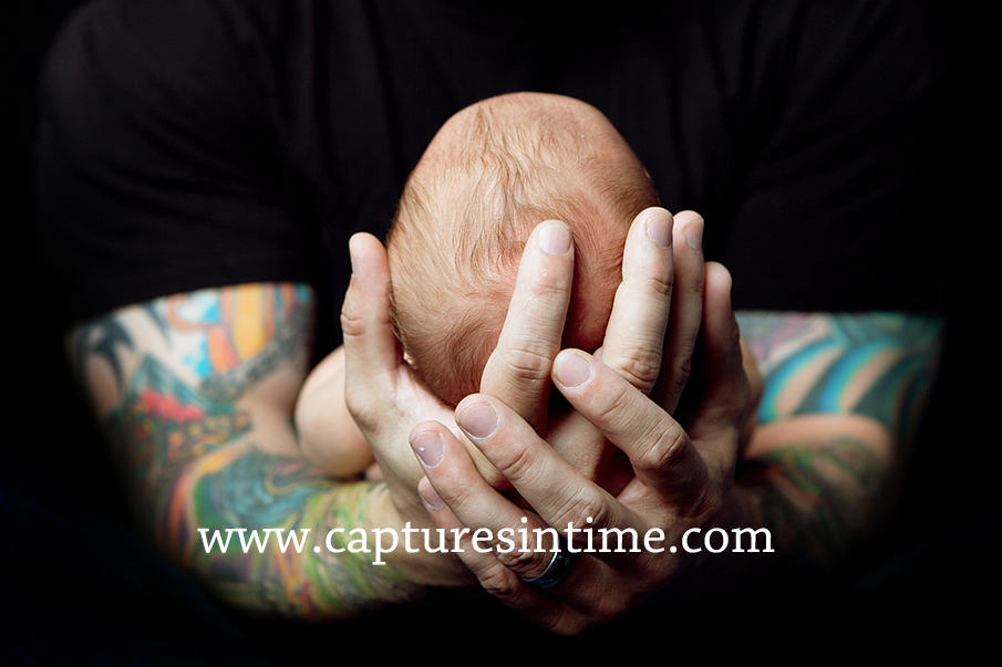 dad tattoos holding baby's head