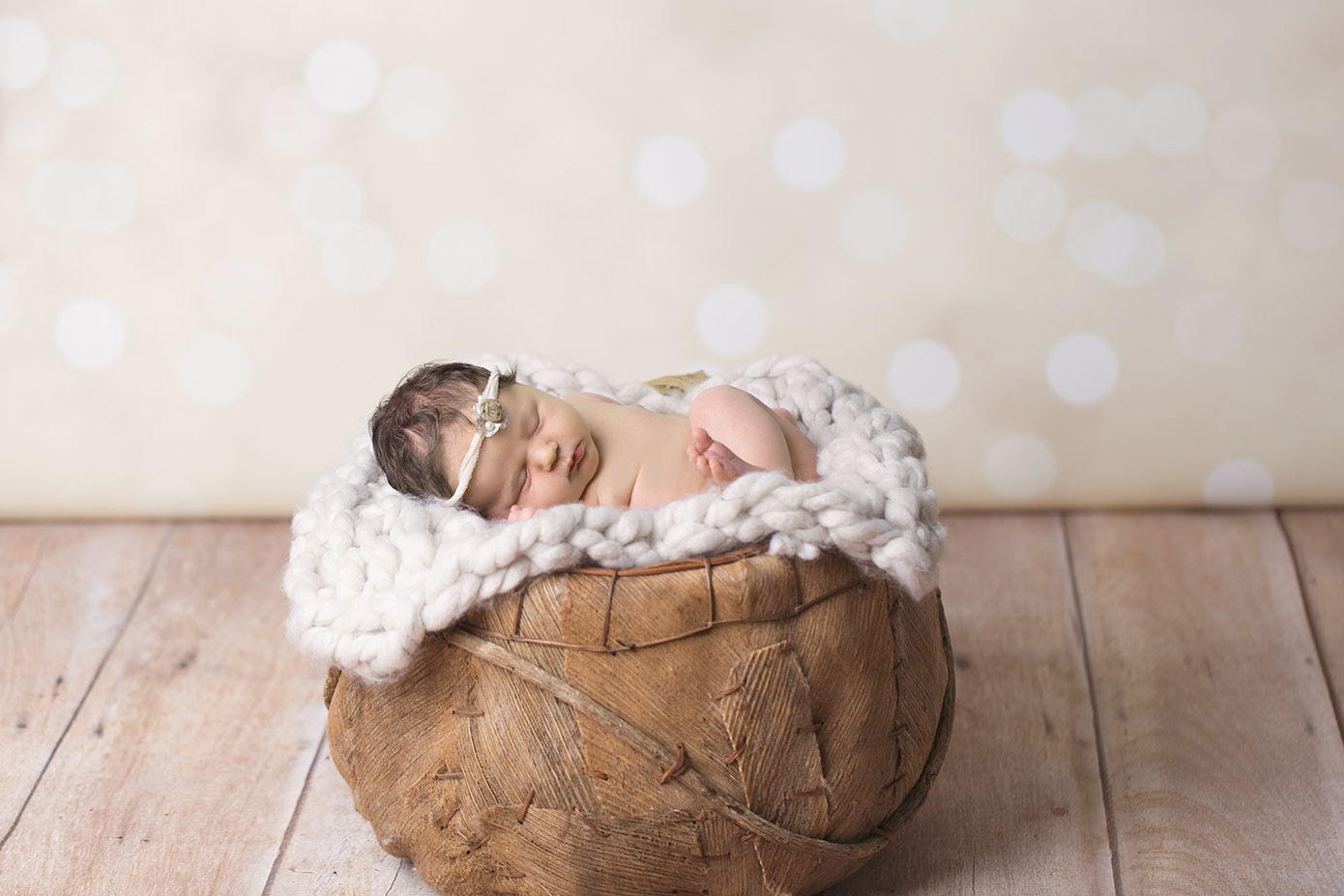 newborn on polka dot backdrop rustic basket