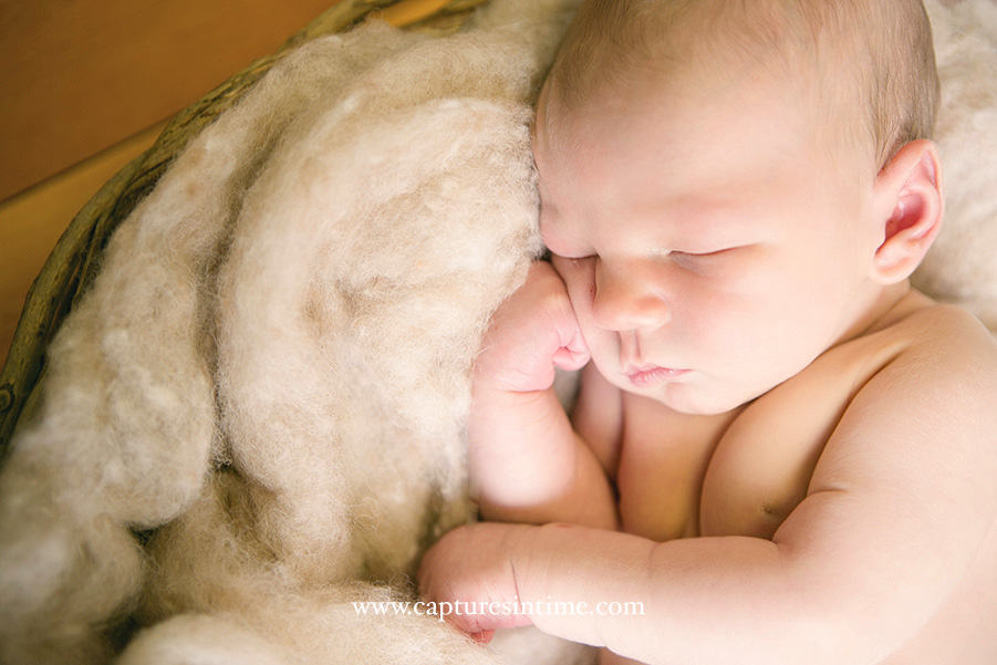 Kansas City Golf Newborn Photography sweet little baby with his fist on face