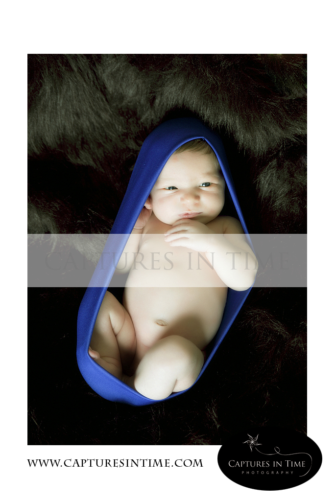 newborn boy in blue cocoon