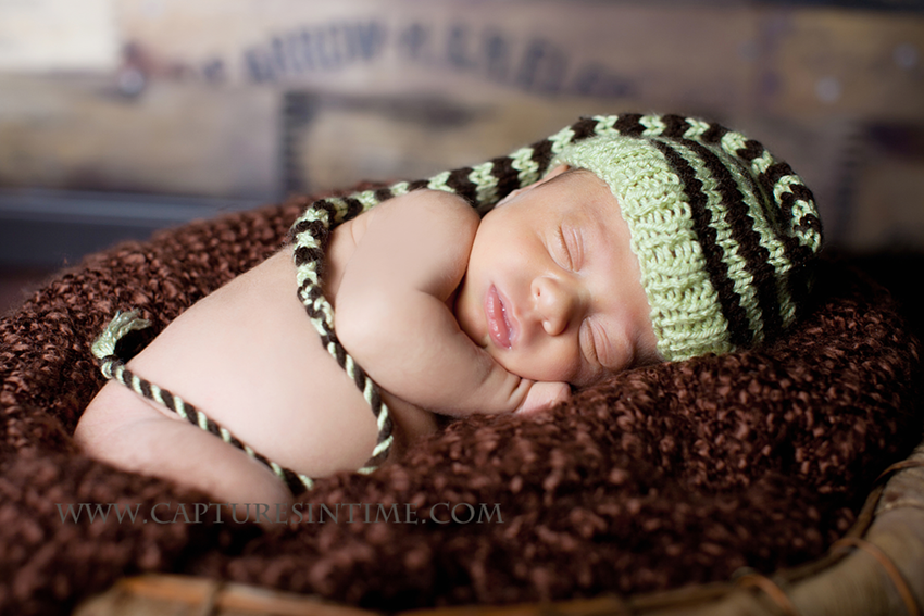 newborn in a green elf hat 