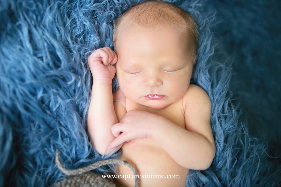 Lees Summit Newborn Photographer newborn boy on bright blue rug