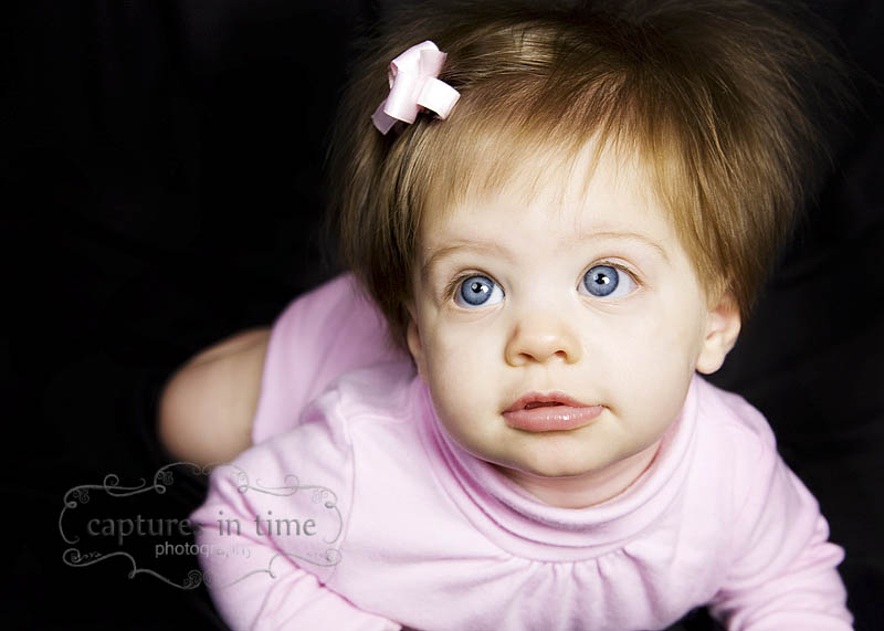 3 month girl with blue eyes on black background
