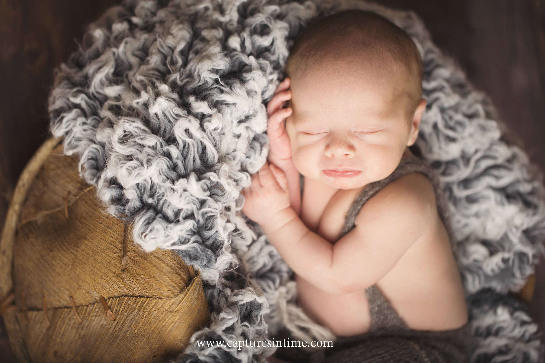 best kansas city newborn photos newborn boy resting his head on his hands in our Blue Springs portrait studio