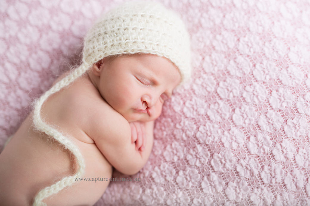 kansas city newborn baby photography newborn girl sleeping on pink lace fabric with cream mohair hat