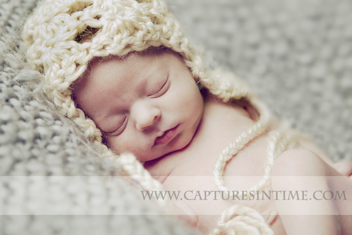 Kansas City Newborn Photographer photographs baby with cream knit hat