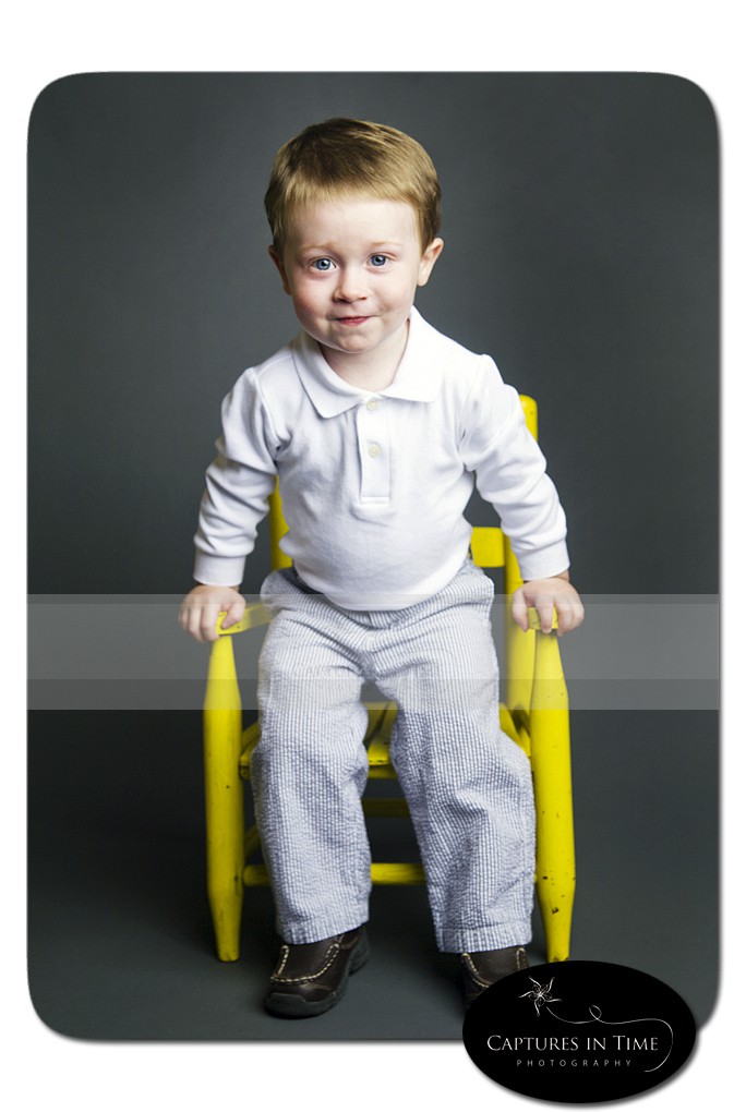 Kansas City Child Photographer boy on a grey background in yellow chair
