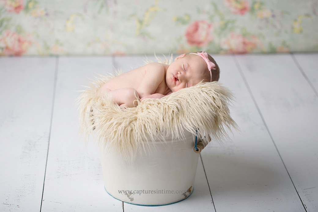 kansas city newborn baby photography newborn baby girl sleeping in a white bucket with floral backdrop