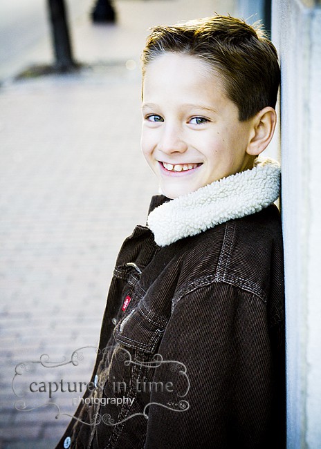 boy smiling brown coat